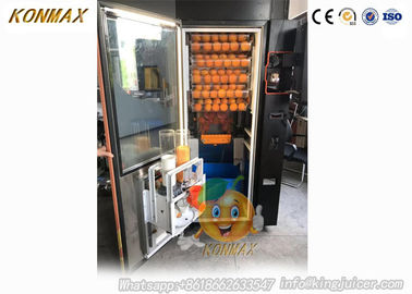La máquina expendedora comercial del zumo de naranja del centro comercial acuña y observa aceptadores